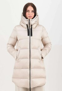 Giacca puffer beige chiaro con colletto alto, zip nera e tasche. Presenta un motivo trapuntato e un orlo leggermente più lungo.