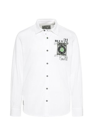 Camisa blanca de manga larga con cierre de botones. Presenta un estampado de logo y texto en el lado izquierdo del pecho, botones negros y una tela suave y texturizada.