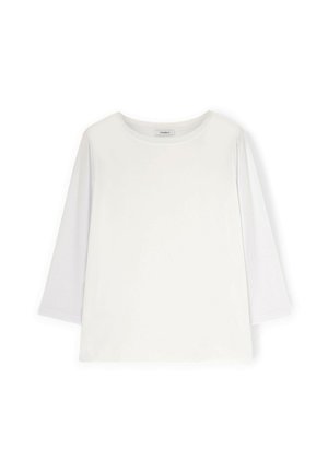 Camisa blanca de manga larga con cuello redondo y ajuste ligeramente holgado, presentada plana sobre un fondo blanco.