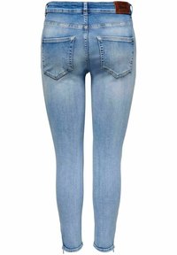 Tajta jeans i ljusblå denim med en slät yta, två bakfickor och en läderlogga vid midjan.