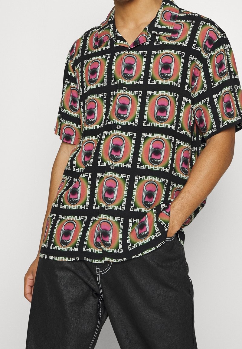 Camicia a maniche corte con sfondo nero, decorata da vivaci motivi di bocca e testo nei colori rosa, verde e bianco, realizzata in tessuto leggero.
