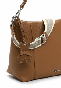 Pruun nahast käekott tekstureeritud pinnaga, millel on mitmevärviline triibuline rihm ja karukujuline ripats dekoratiivseks aktsendiks.