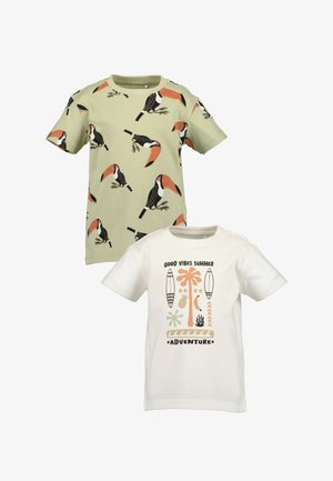 Deux t-shirts pour enfants : l'un vert clair avec un imprimé de toucan, l'autre blanc avec des graphismes et du texte sur le thème de l'été dans diverses couleurs.