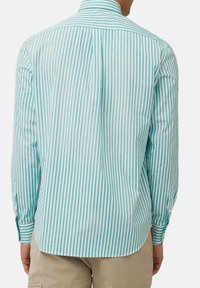Langarmshirt met een lichtblauw en wit verticaal gestreept patroon, gemaakt van ademende stof, met een kraag en enkele knoopmanchetten.