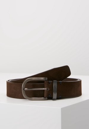 Ceinture en cuir marron avec boucle argentée mate et "JOOP !" gravé sur la boucle de maintien, enroulée sur une surface blanche.