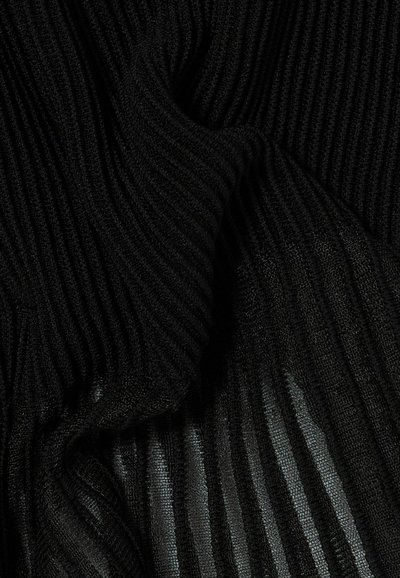Tessuto a maglia nero a coste con pieghe che mostrano motivi a righe semitrasparenti e texturizzati.