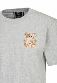 Grijze katoenen t-shirt met een bedrukt berenontwerp op de linkerkant van de borst, met rode sterrenaccenten en oordetails. Korte mouwen, ronde hals.