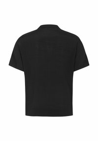 Maglietta nera a maniche corte con vestibilità rilassata, colletto semplice e texture morbida, caratterizzata da un design pulito e semplice senza motivi.
