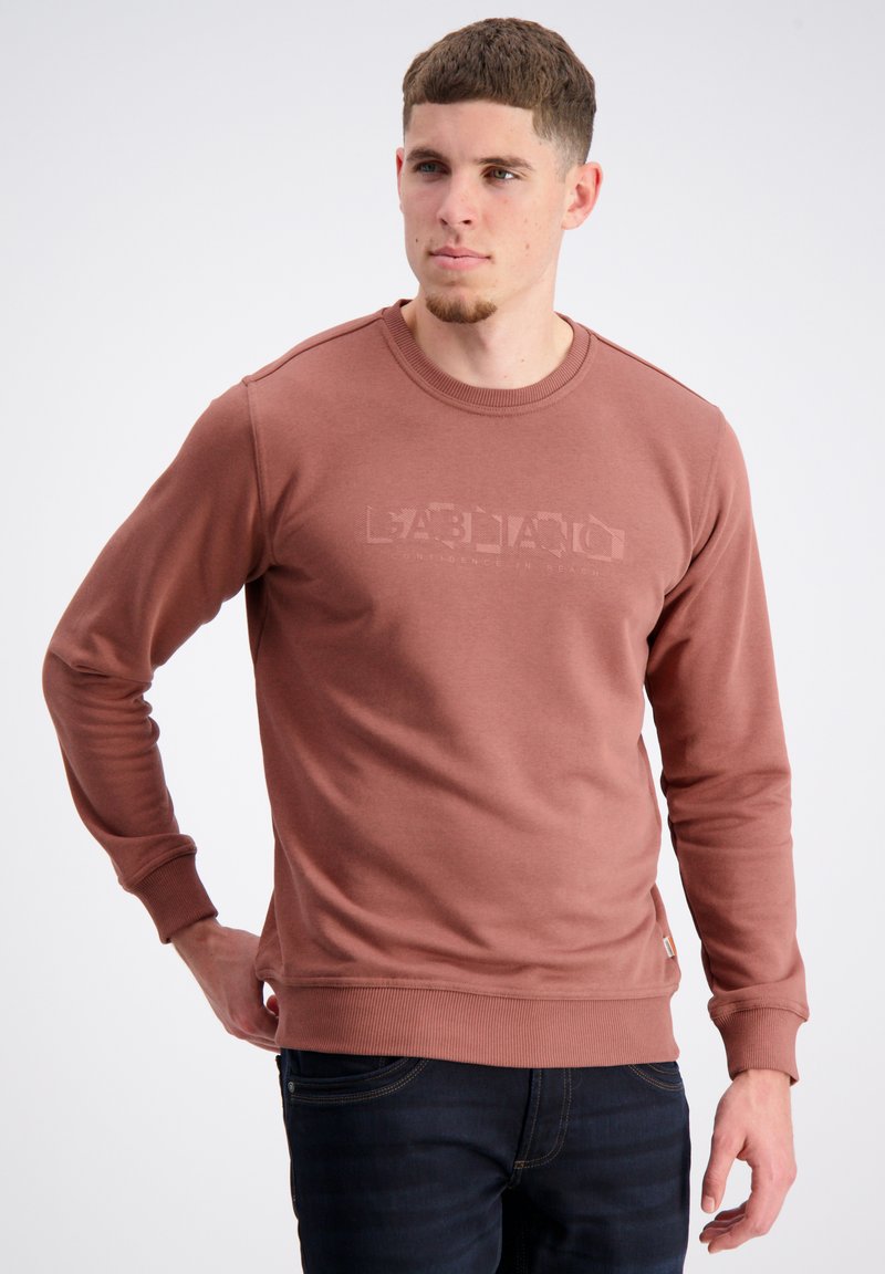 Brązowy sweter z okrągłym dekoltem wykonany z miękkiej, teksturowanej tkaniny z wytłoczonym nadrukiem logo. Wyróżniające się ściągacze przy mankietach i na dolnym brzegu oraz mała metka marki z boku.