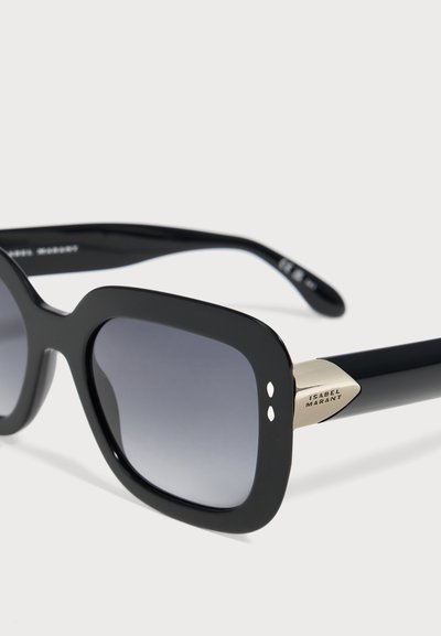 Lunettes de soleil carrées noires avec des verres foncés dégradés et un détail doré sur la branche, gravé du nom de la marque "ISABEL MARANT".