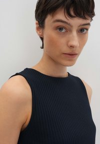 Top senza maniche a coste navy con scollatura rotonda, design aderente e texture liscia. Presenta cuciture minimali e linee pulite.