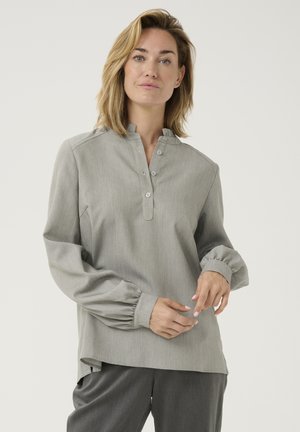Light gray long-sleeve blouse with a mandarin collar, buttoned placket, and gathered cuffs. Made from smooth fabric with a subtle texture.