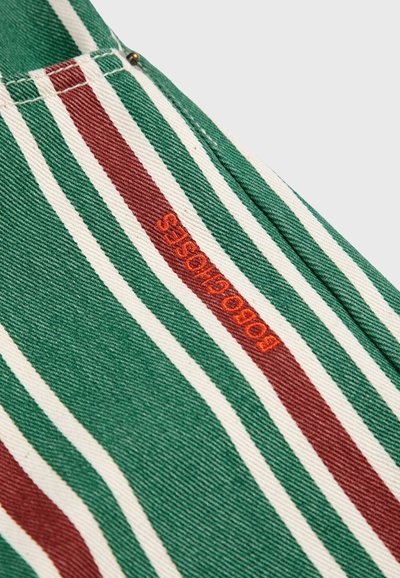 La tela a rayas presenta colores verde, blanco y marrón con una textura prominente. Incluye un logo naranja que dice "Bobo Choses."