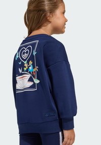 Teget plava dukserica s grafikom na leđima koja prikazuje šalicu čaja i likove iz Disney teme, izrađena od mekog, teksturiranog materijala.