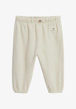 Cremefarbene, weich strukturierte Babyhosen mit elastischem Bund, einem einzelnen Holzknopf und kleinem Koala-Logo-Patch auf der vorderen rechten Seite.