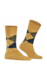 Calzini gialli con un motivo argyle verde e blu. La texture del tessuto è liscia, con sezioni rinforzate nella punta e nel tallone.
