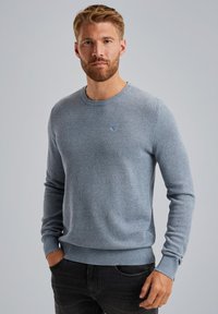 Helltblauer Strickpullover mit rundem Ausschnitt, strukturierter Musterung und gerippten Abschlüssen an Ärmeln und Saum. Kleines Logo-Detail auf der Brust.