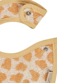 Gelbes und weißes Futterlätzchen aus einem strukturierten Frottiertuch mit einem gepunkteten Muster. Die Ränder sind mit einem glatten Stoffbesatz und Druckknopfverschlüssen versehen.