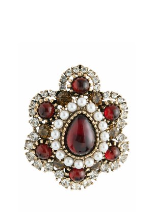 Brooch with a large red teardrop center stone, surrounded by white pearls, smaller red and brown stones, and clear crystals in gold setting.