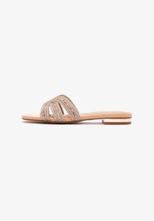 Flat sandal with a nude sole and multi-strand, textured upper featuring woven gold and rose metallic accents. Minimalist design with low heel.