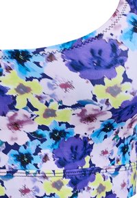 Débardeur floral en tissu extensible, présentant un motif vibrant de fleurs violettes, bleues et jaunes, avec une texture lisse et des coutures en zigzag.