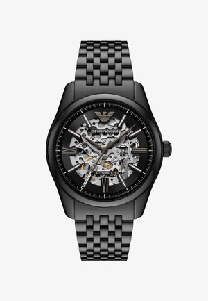 Czarny automatyczny zegarek z przezroczystym szkieletowym cyferblatem, srebrnymi mechanicznymi elementami, srebrnymi znacznikami godzin i matową czarną bransoletą ogniwową.