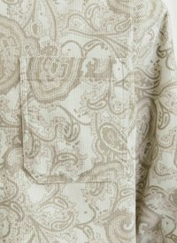Țesătură de culoare deschisă cu un model subtil paisley în bej și crem. Prezintă o buzunare aplicată și o textură ribbabilă.