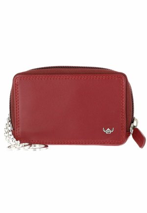 Petit porte-monnaie en cuir rouge avec fermeture éclair et petit emblème argenté à l'avant, attaché à une courte chaîne argentée avec porte-clés.