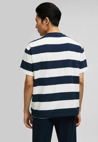 Navy and white striped short-sleeve t-shirt with a relaxed fit, crew neckline, and soft cotton material, detailed stitching along the hem.
