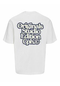 Valge puuvillane T-särk, mille seljal on suur tumesinine graafika tekst, mis ütleb "Originals Studio Edition Cph©" paksu ja ümarate tähtedega.