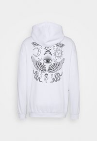 Sweat à capuche blanc avec des illustrations mystiques noires au dos, comprenant un œil central avec des ailes, le soleil, la lune, des serpents, des papillons et des poignards croisés.