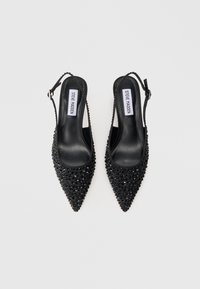 Pantofi cu toc slingback negri, ascuțiți, cu strasuri strălucitoare, curea ajustabilă cu cataramă și logo-ul Steve Madden pe interiorul branțului.
