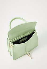 Green leather handbag with a top handle, featuring a gold clasp and a divided interior, showcasing a smooth texture and structured design.