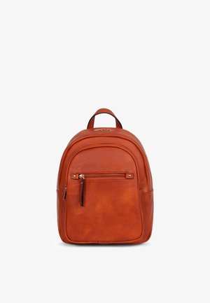 Sac à dos compact en cuir marron avec poche zippée à l'avant, poignée supérieure et double fermeture éclair sur fond blanc.