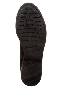 Suela de zapato negro hecha de goma con un patrón texturizado para mejorar el agarre, presenta el logo de la marca y orificios de drenaje para la gestión de la humedad.