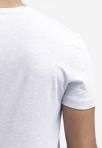 Grijze katoenen t-shirt met een ronde hals, met een gladde textuur en korte mouwen, gezien vanaf de achterkant.