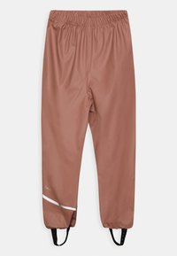 Pantalon résistant à l'eau, taille mi-haute, de couleur rouille unie, avec une ceinture élastique, des sangles réglables aux chevilles et des accents réfléchissants blancs.