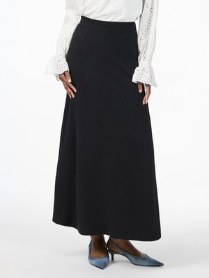 Jupe noire longue avec un tissu lisse et texturé et une taille ajustée, associée à des escarpins à talons aiguilles bleu clair.