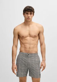 Heren zwemshorts van een bedrukt stof met een combinatie van marineblauw en wit. Elastische tailleband met een knoop aan de voorkant, gestructureerd oppervlak, relaxte pasvorm.