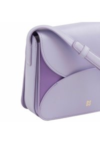 Borsa a tracolla in pelle lilla con un design strutturato, caratterizzata da accenti lavanda a contrasto e un logo minimalista in oro. Incluso un cinghia regolabile.