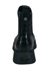 Botín negro hasta el tobillo con textura de cocodrilo, suela gruesa, emblema metálico de la marca en la parte trasera y tira de agarre en la parte superior.