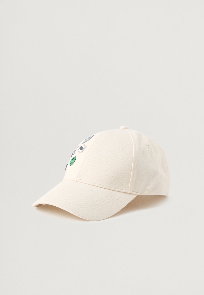 Gorra de béisbol de algodón color beige claro con visera curvada, que presenta varios parches pequeños coloridos y bordados en la parte frontal.