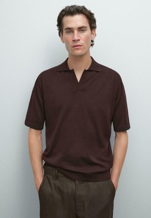 Brown short-sleeve polo shirt with a open collar, smooth texture, paired with dark trousers, on a neutral background.
