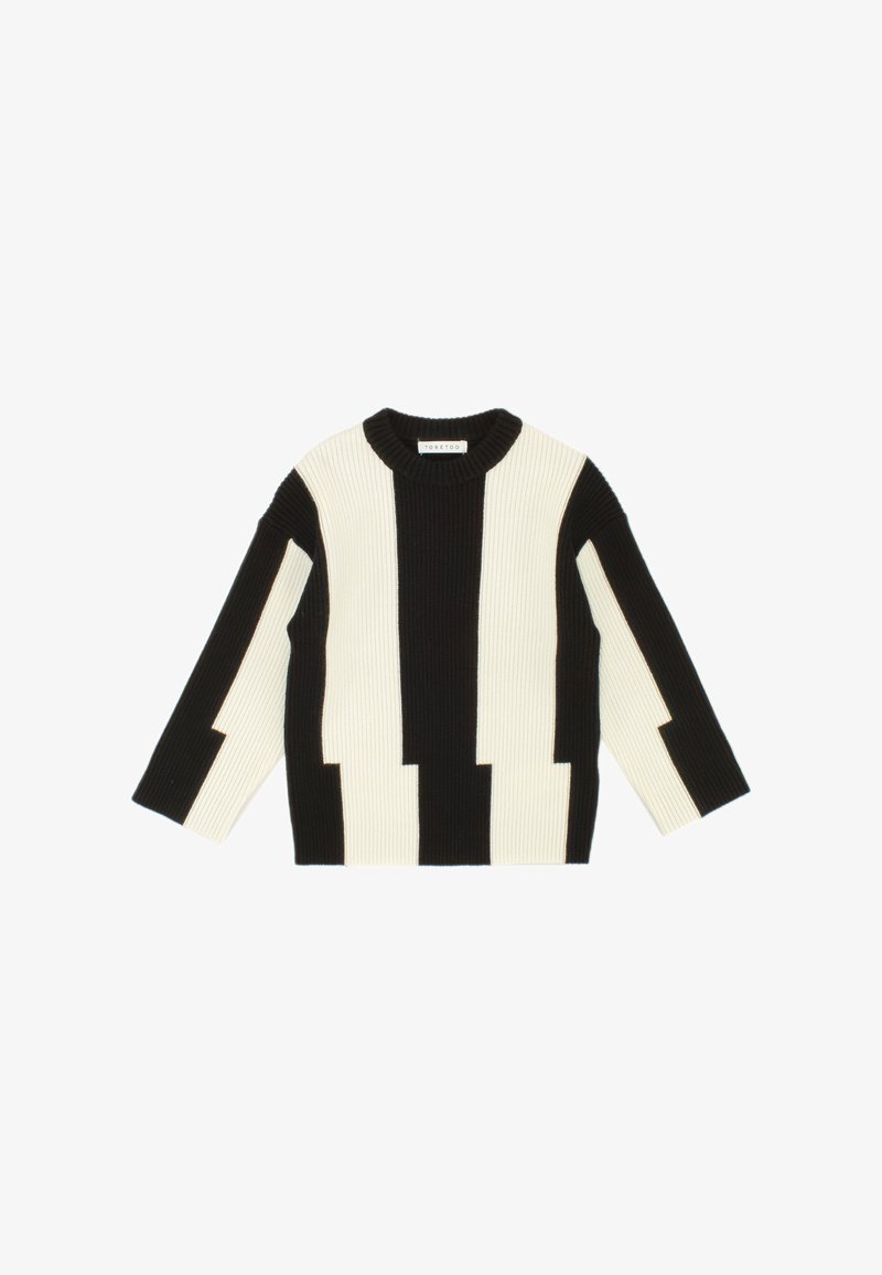 Black and white ribbed sweater with a boxy fit, featuring contrasting block patterns and a round neckline. Long sleeves with wide cuffs.