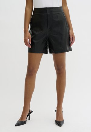 Shorts en cuir noir à taille haute, présentant une texture lisse, deux poches avant et des lignes épurées et ajustées.