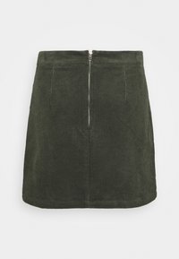 Falda de pana verde oscura con corte recto y cremallera frontal; presenta una textura de costillas verticales y un dobladillo limpio.