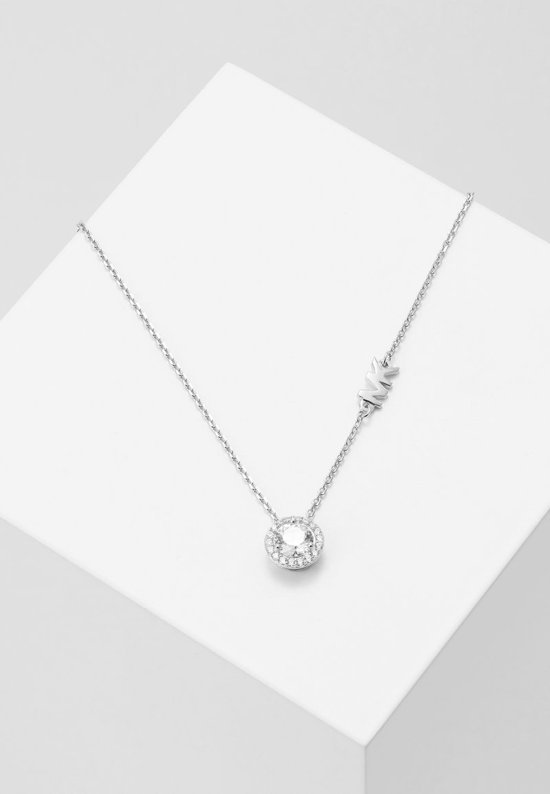 Collana d'argento con un pendente rotondo che presenta una pietra centrale trasparente circondata da pietre più piccole, su una delicate catena.