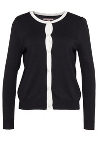 Svart kofta med vit knappslå och kant. Har långa ärmar och pärl-liknande knappar. Tillverkad av mjukt stickat material.