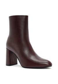 Bottine en cuir brun foncé avec un bout pointu et un talon bloc haut, présentée de profil sur un fond blanc.