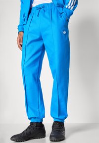 Φωτεινά μπλε παντελόνια jogging με ελαστική μέση και μανσέτες, με πλαϊνές ραφές και μικρό κεντητό λογότυπο στο αριστερό ισχίο.